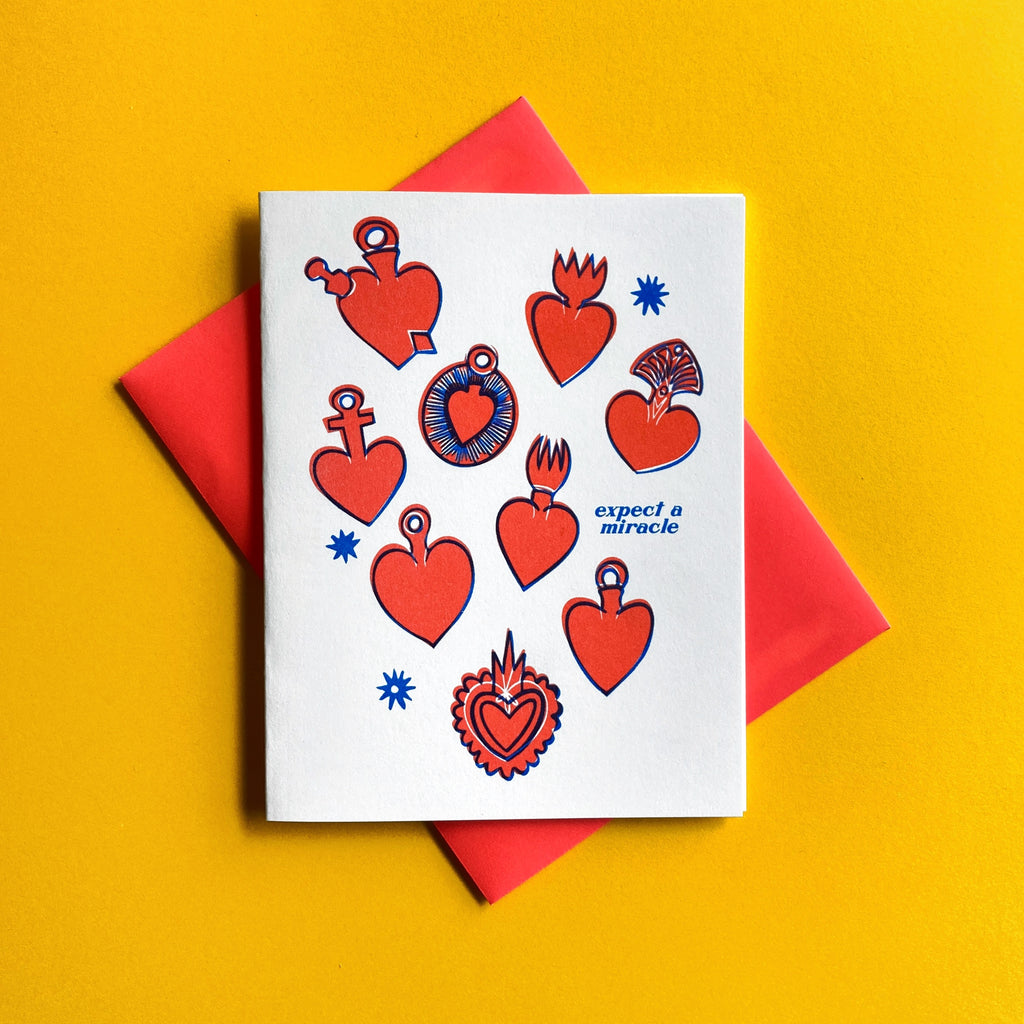 heart ex vote Milagros with text "expect a miracle" shown on a yellow background with neon red envelope