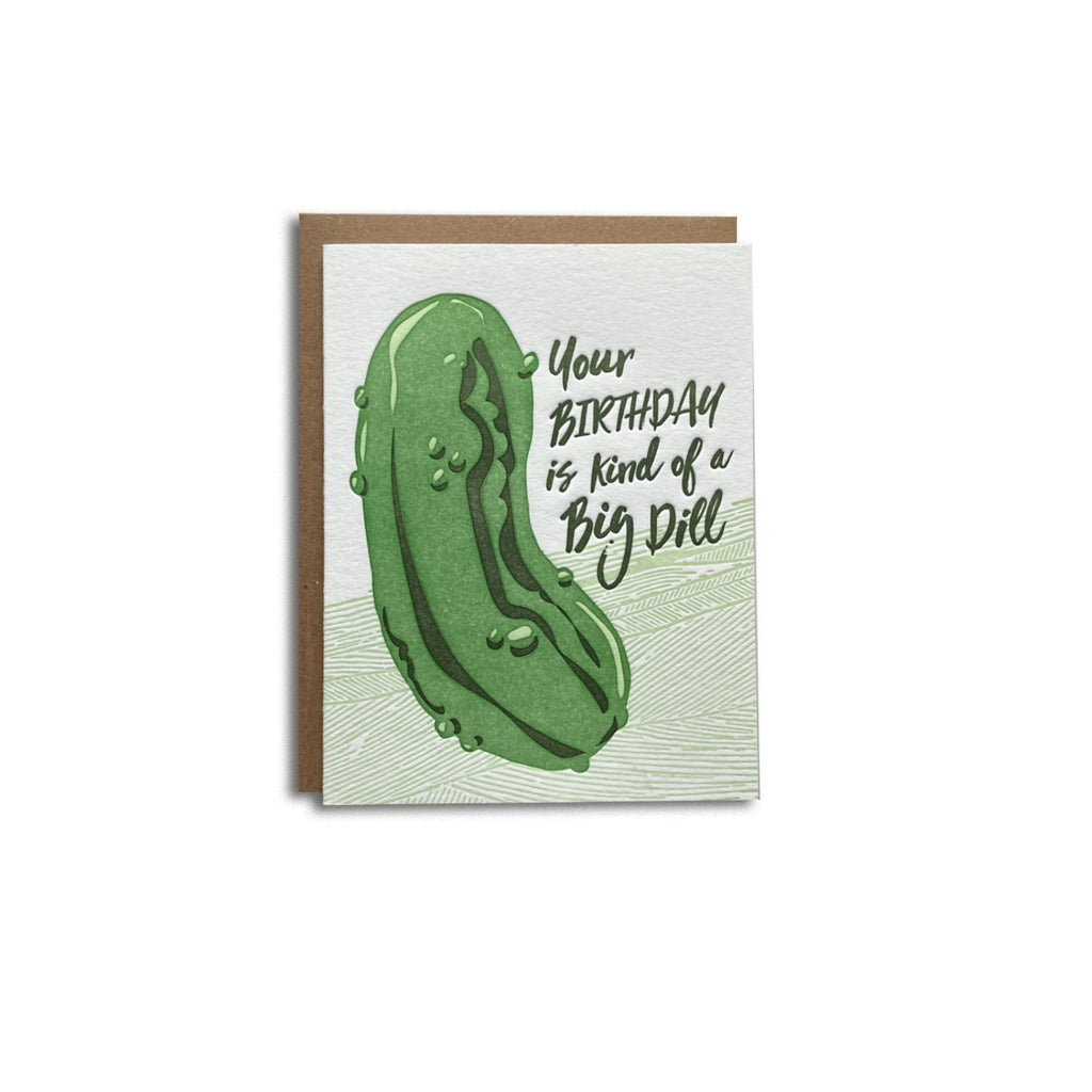 Letterpress birthday card, funny birthday card with pickle, text says "your birthday is kind of a big dill". pickle pun birthday card. Shown with a kraft envelope on a white background